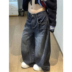 Person wearing wide-leg jeans and a cropped sweater in a room with wooden flooring.