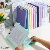 Colorful file folders on a desk with a hand holding one open, in front of a pegboard with office supplies.