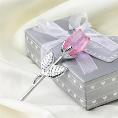 Decorative rose with pink gem and silver accents on a gift box with white ribbon