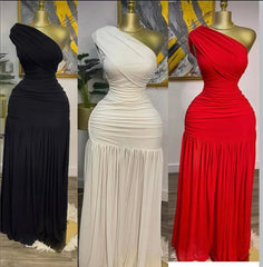Three mannequins wearing black, white, and red one-shoulder evening gowns in a room setting.