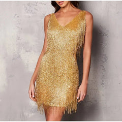 Gold fringe dress worn by a model against a textured gray background