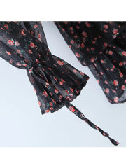 Black floral-patterned headband on a light gray background