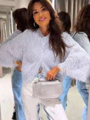 Woman holding a silver handbag in front of mirrors