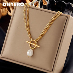 Gold necklace with a pearl pendant on a beige box, brand 'DIEYURO' visible
