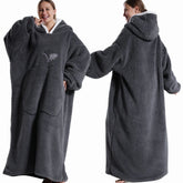 Person wearing a gray hoodie with a blanket attached, shown from front and back views.