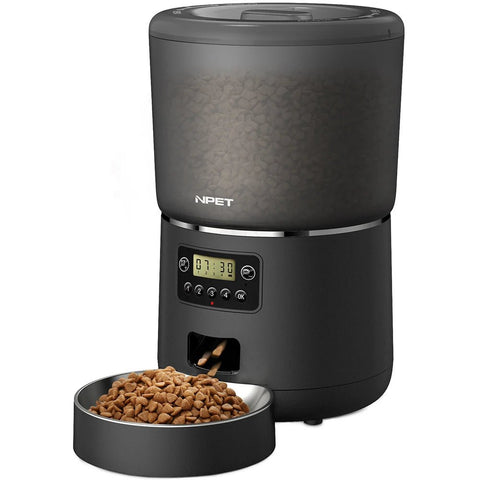 Black pet food dispenser with digital display and a bowl of kibble on a white background