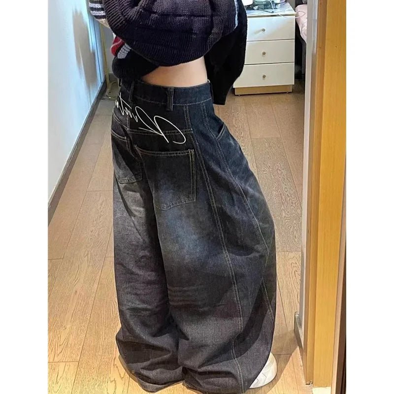 Person wearing wide-leg jeans in a room with wooden flooring.