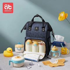 Navy blue diaper bag with baby care items on a white background