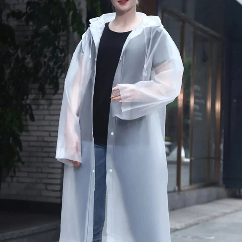 Person wearing a transparent raincoat over a black top and jeans in an urban setting.