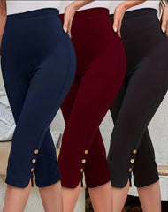 Three pairs of capri leggings in navy, red, and black with button details on a neutral background.