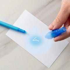 Hand using a blue marker to write on a piece of paper with a white background