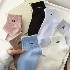 Collection of colorful socks with a brand logo on a light background