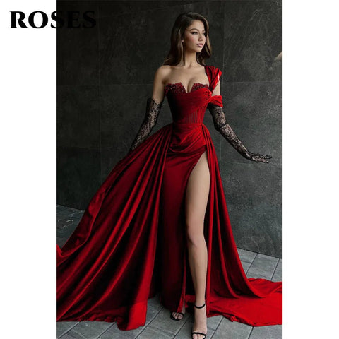 Woman in a red dress with a high slit standing against a dark background