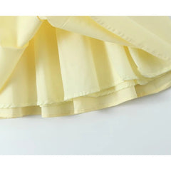 Close-up of a light yellow ruffled fabric on a white background