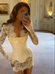 Woman taking a mirror selfie wearing a lace dress in an elegant room.