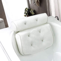A white 3D mesh bathtub pillow with suction cups on a bathtub, designed for head, neck, back, and shoulder support.