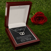 A heart-shaped necklace with cubic zirconia crystals, presented in a red and white gift box with a green velvet interior, alongside a red rose.