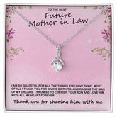 A necklace with a silver finish and a pendant shaped like a ribbon, presented in a pink box with floral motifs and a quote.