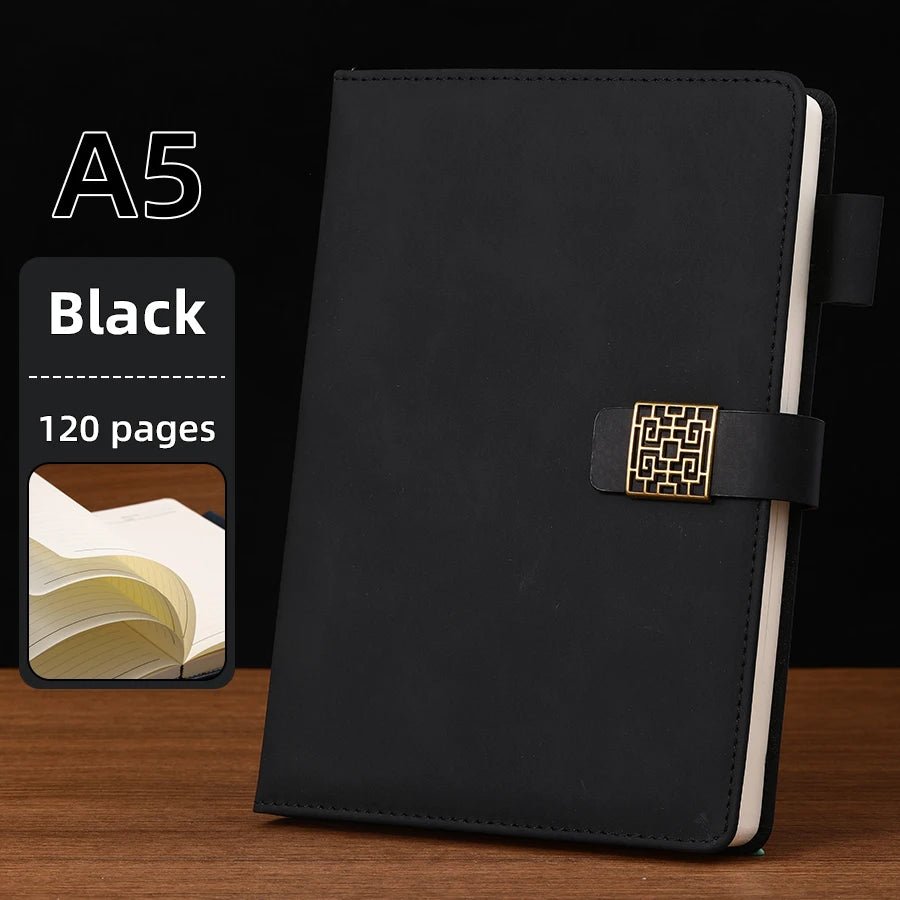 Black A5 notebook with gold buckle on a wooden surface