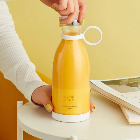 Yellow juice bottle labeled 'Fresh Juice' held by a person against a yellow background