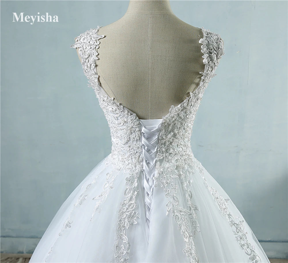 White wedding dress with lace detailing on a mannequin against a light blue background, brand 'Meyisha' visible.