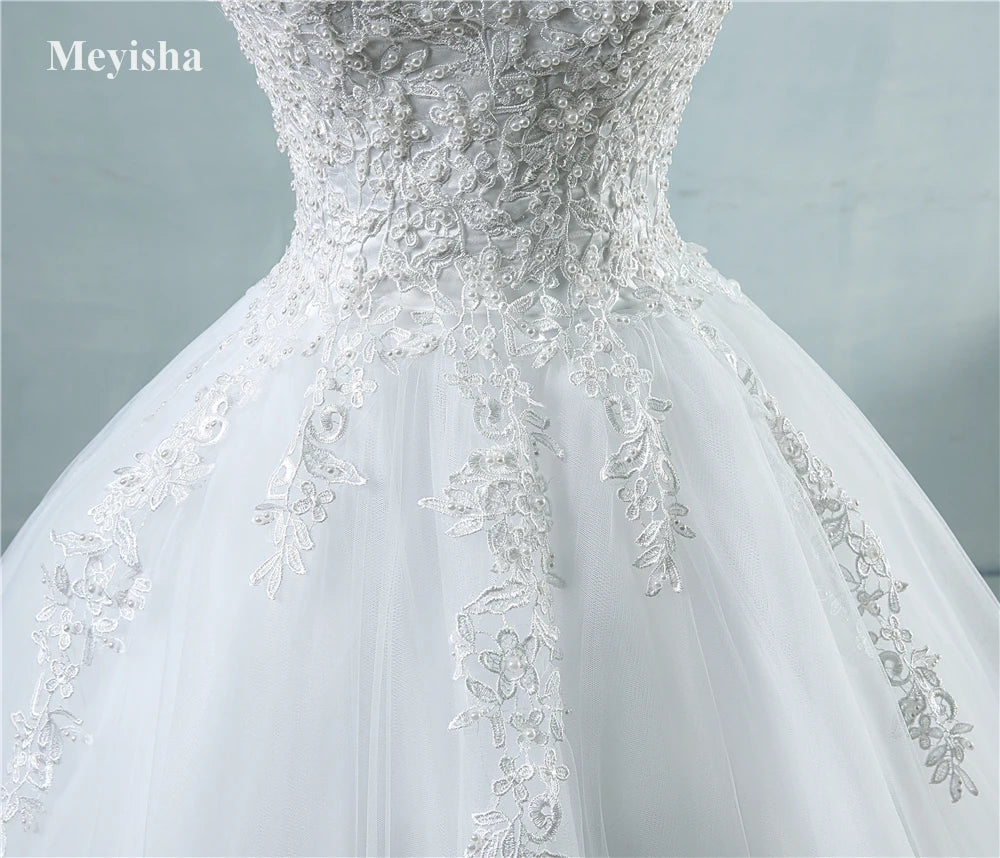 White wedding dress with intricate lace detailing on a light gray background