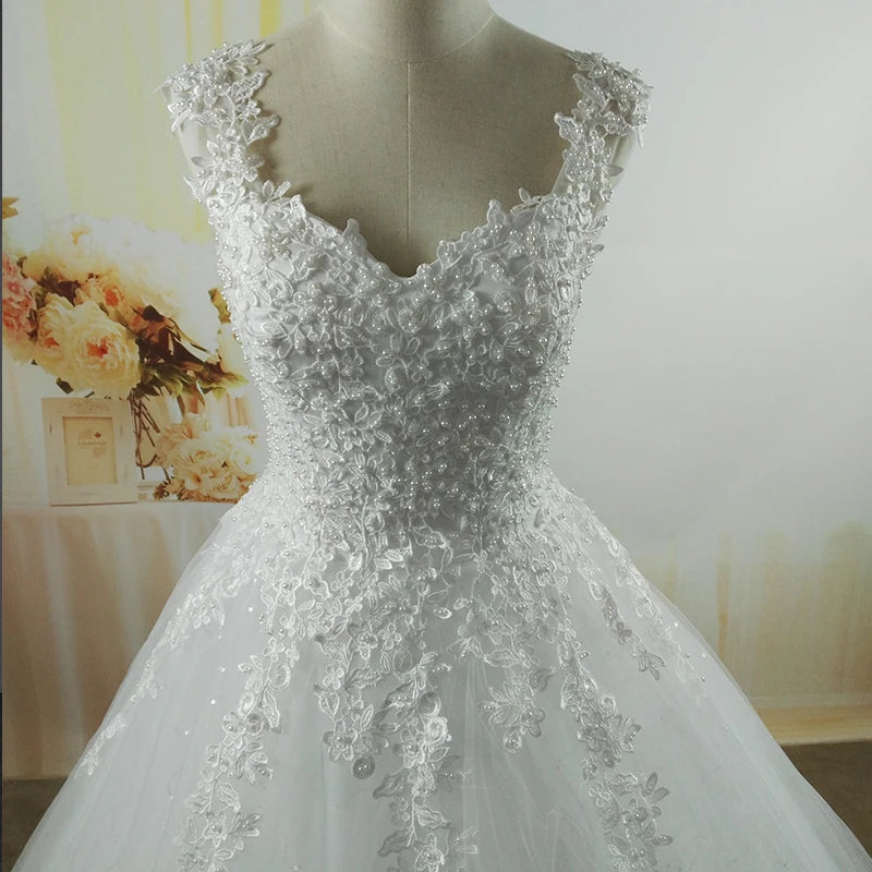 White lace wedding dress on a mannequin with a blurred floral background