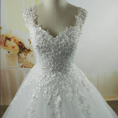 White lace wedding dress on a mannequin with a blurred floral background