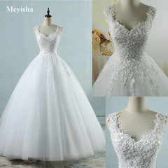 White wedding dress with lace details on a mannequin against a light blue background.
