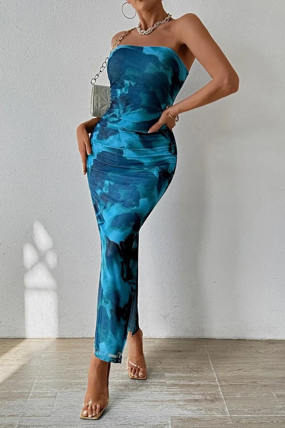 Woman wearing a blue strapless dress with a white background
