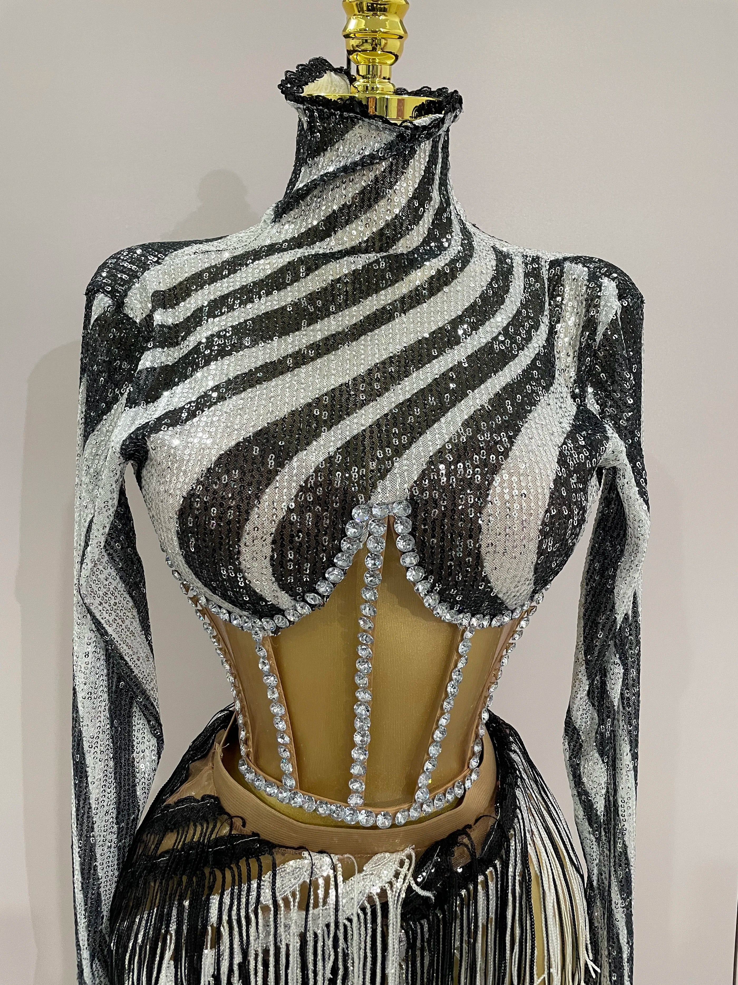 Black and white striped sequin top on a mannequin with fringe details against a plain background