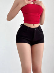Person wearing a red crop top and black shorts on a white background