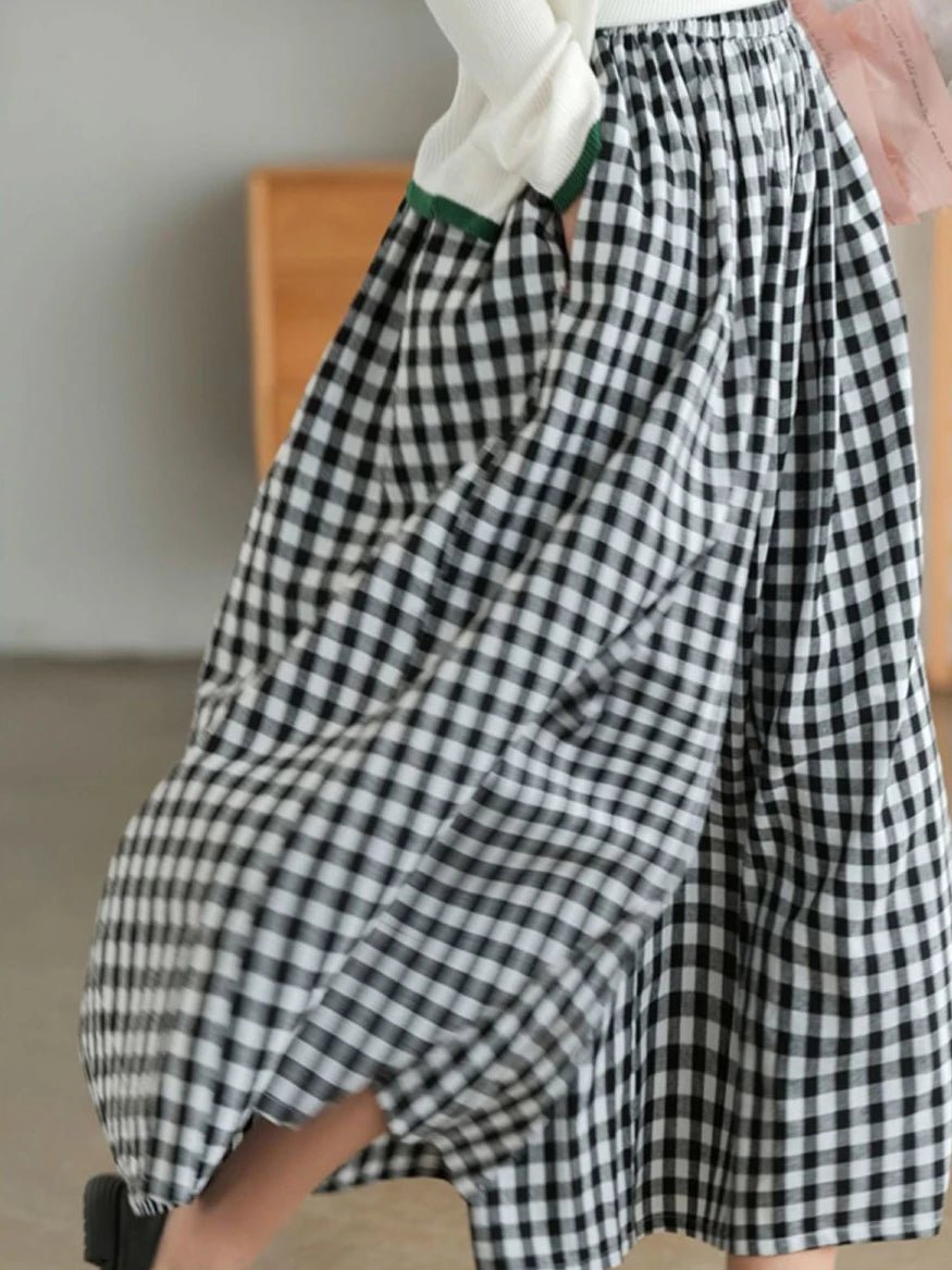 Black and white checkered pant  worn by a person, with a neutral background