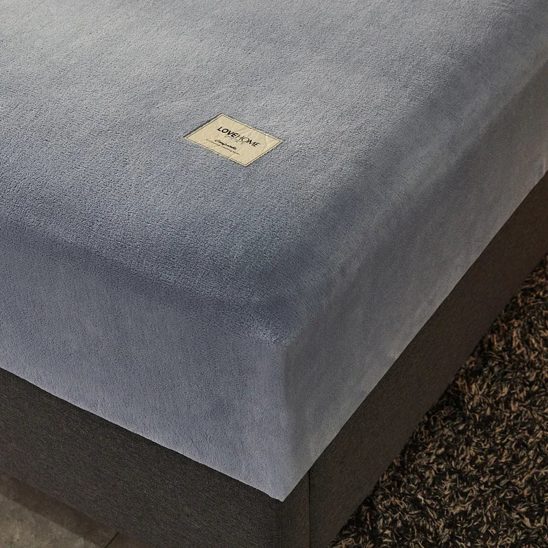 Gray cushioned bench with a visible brand label on a textured surface.