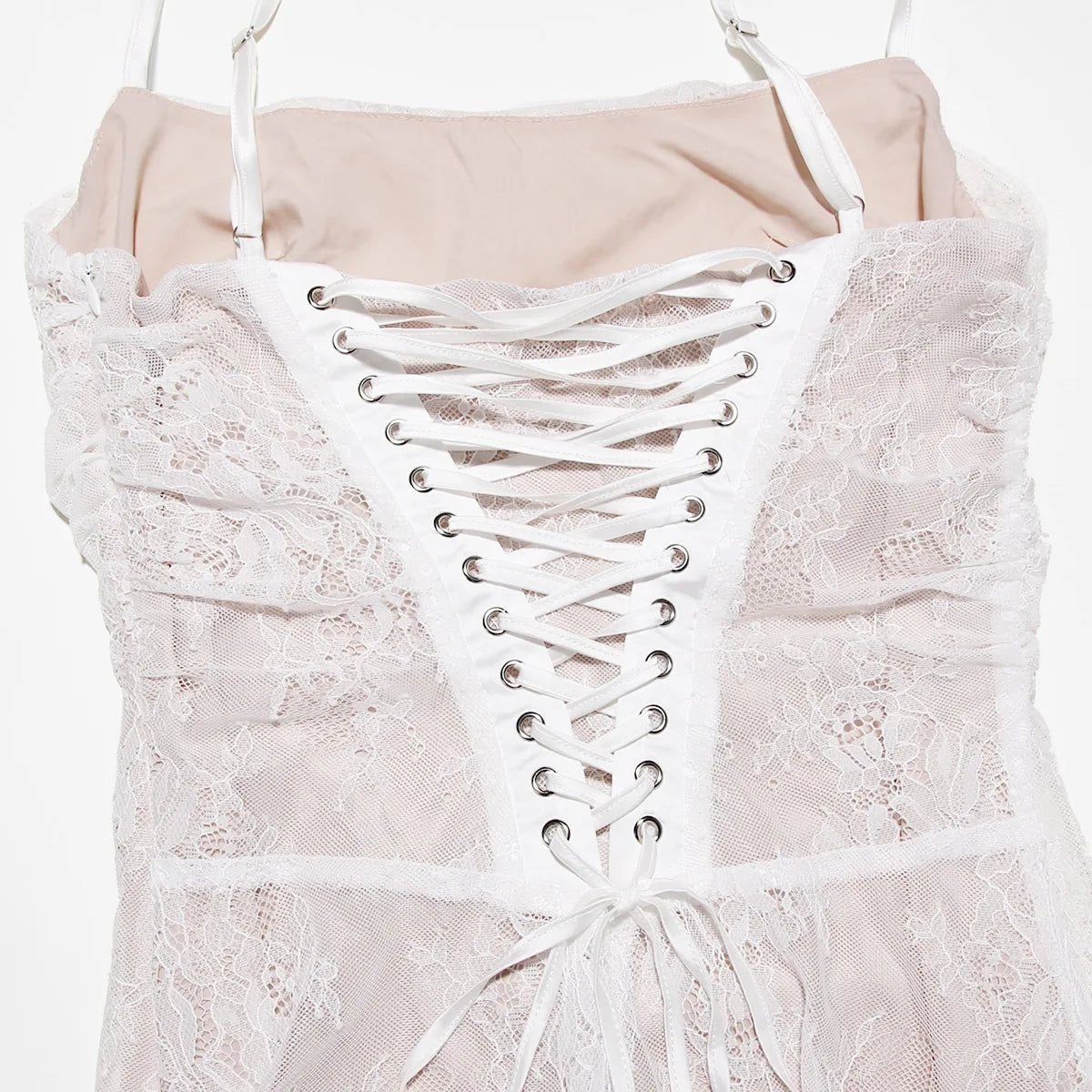 White lace dress with a corset-style bodice on a hanger against a white background
