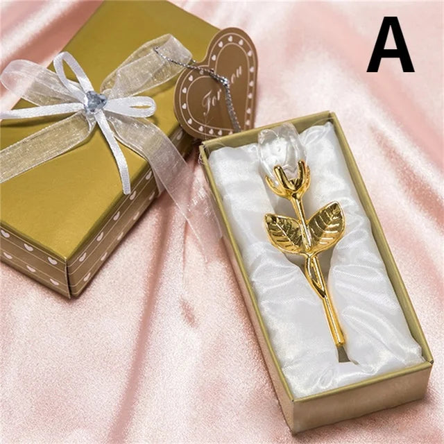 Gold rose-shaped pen in a gift box with a bow on a pink fabric background