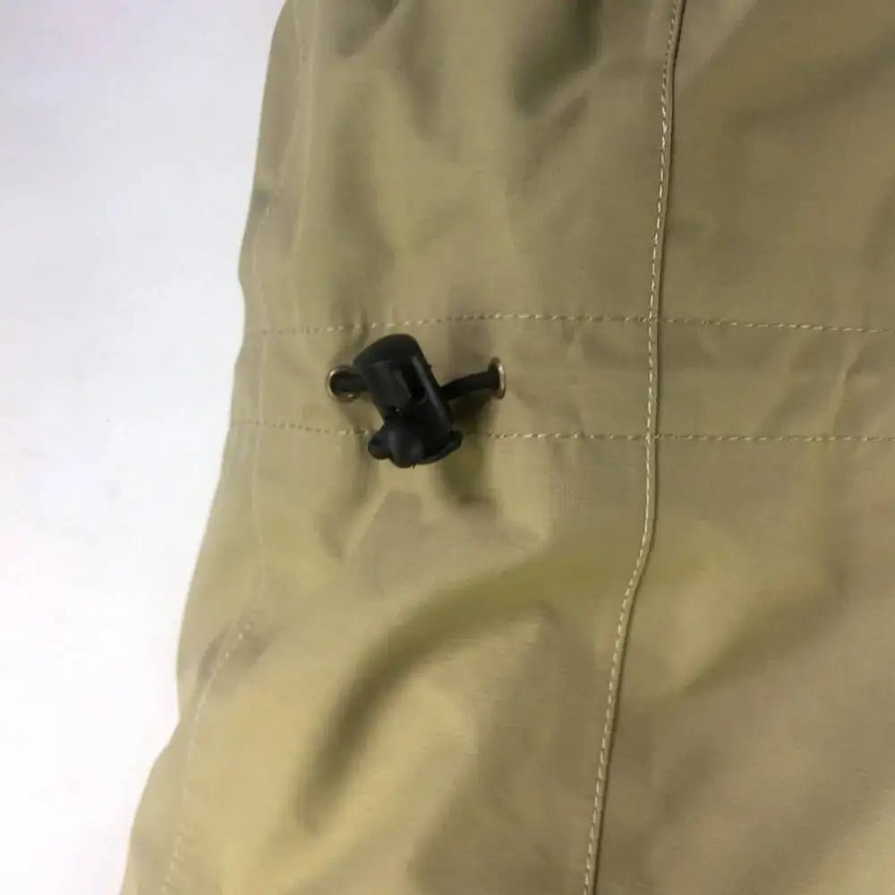 Close-up of a beige jacket with a black button on a white background