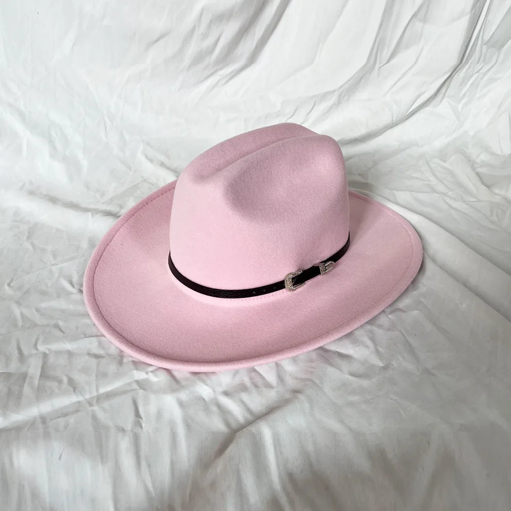 Pink fedora hat with a black band on a white fabric background