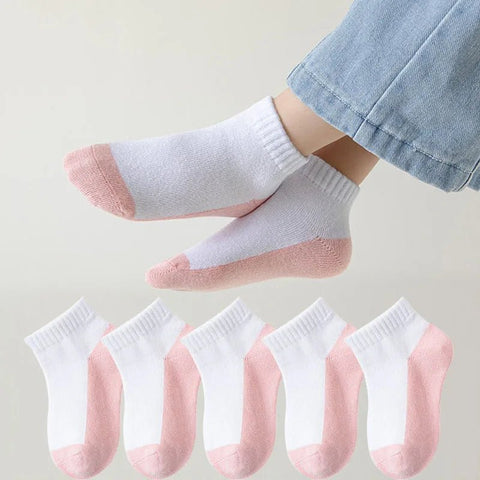 Set of white socks with pink toes and heels displayed on a light background