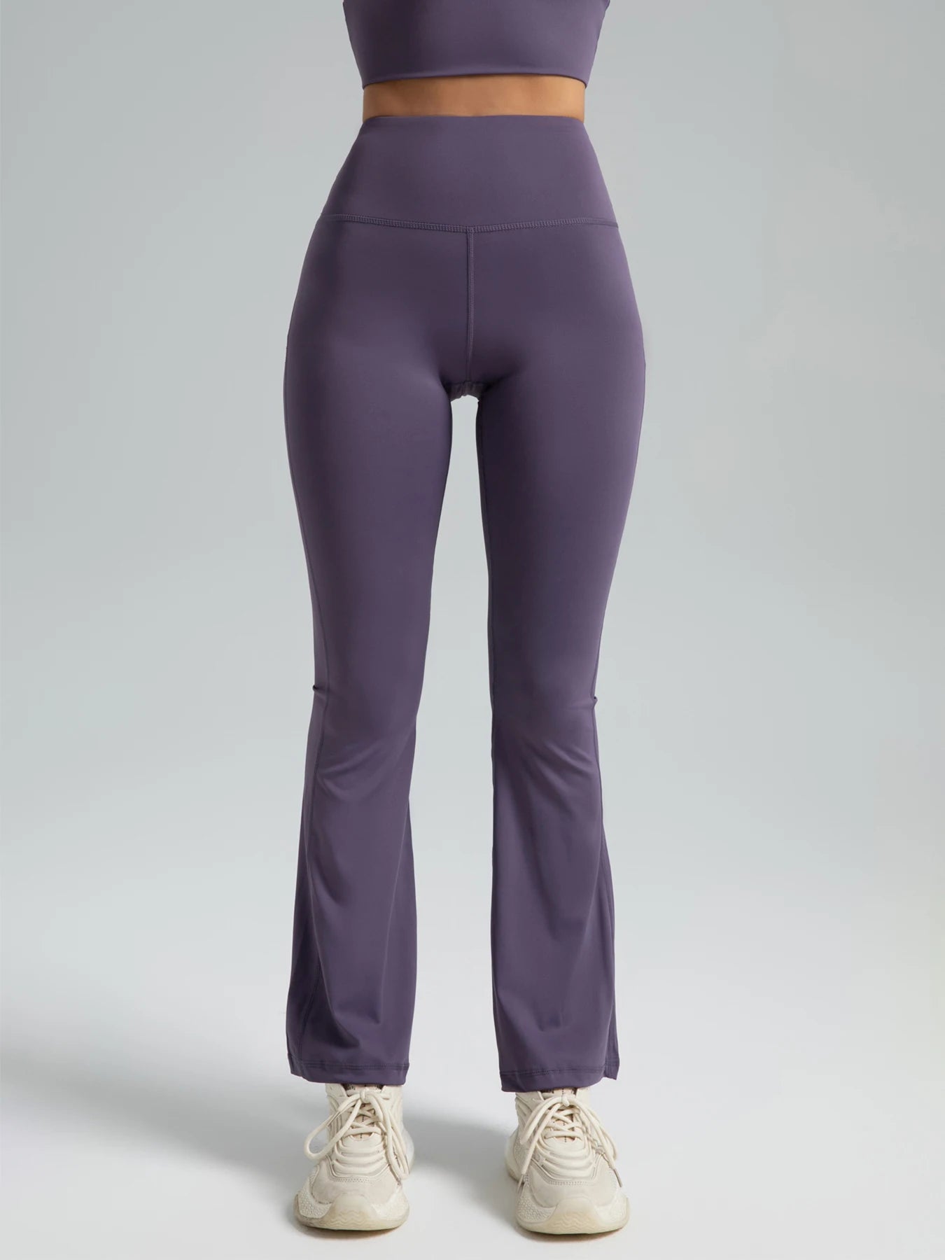 Purple leggings worn by a person on a light gray background