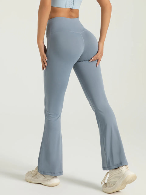 Person wearing light blue flared leggings on a plain background
