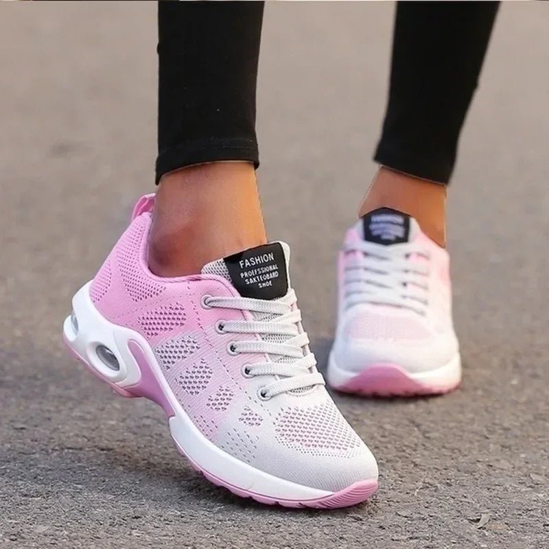Pink and white sneakers worn on a blurred background