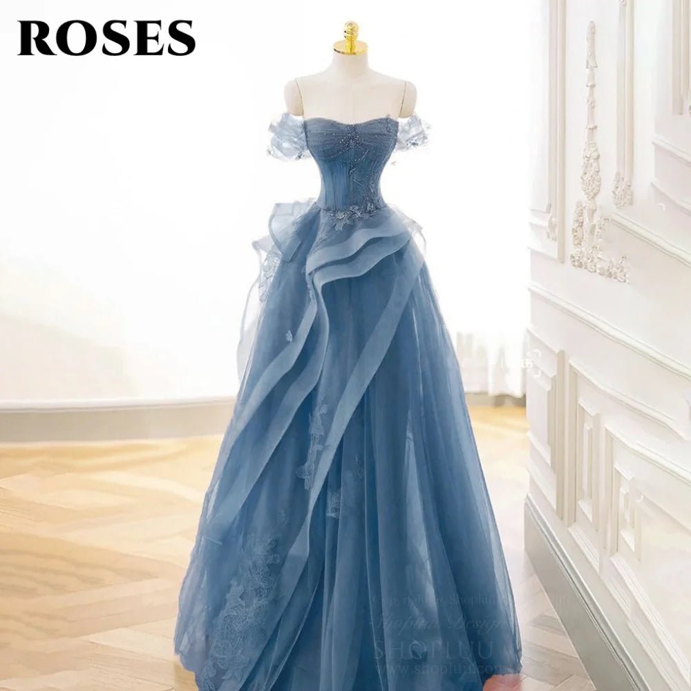 Blue evening gown on a mannequin against a white wall.