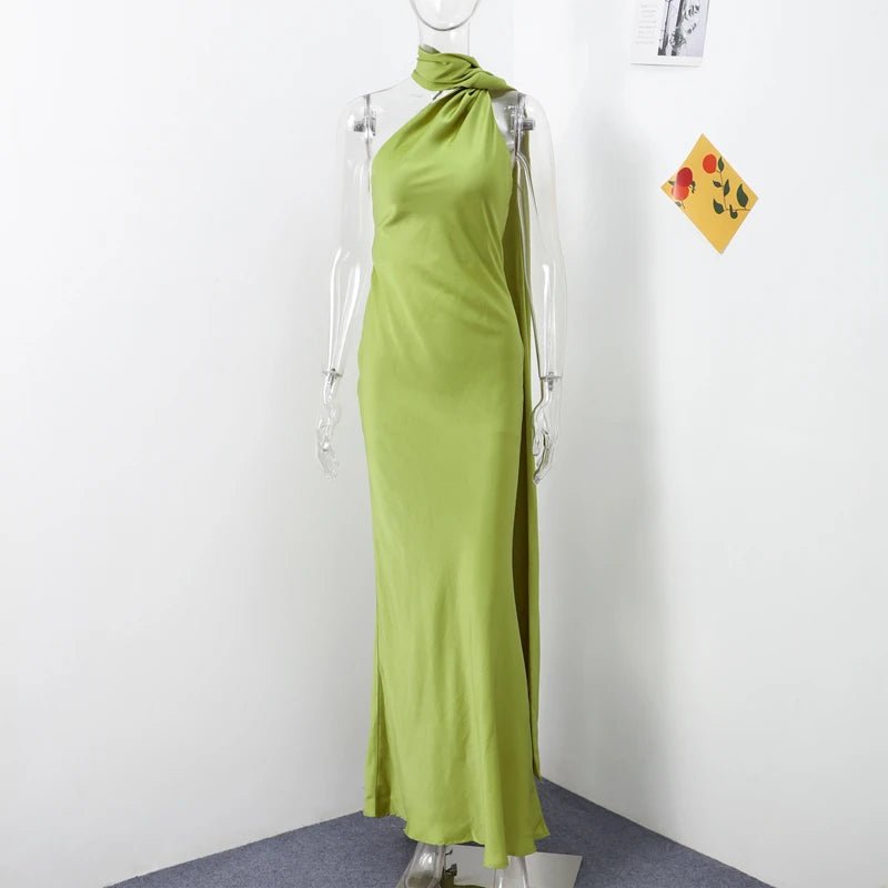 Green halter neck dress on a mannequin against a white wall.