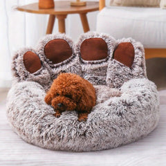 Dog lying on a fluffy, bear-shaped pet bed in a cozy living room.