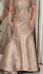 Beige evening gown with intricate beadwork on a neutral background