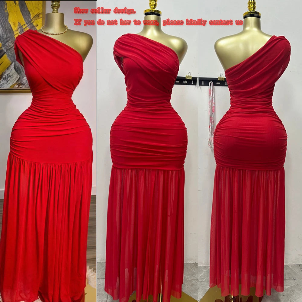 Red one-shoulder evening gown on a mannequin against a white wall.