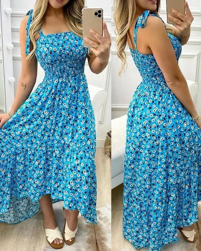 Woman wearing a blue floral dress taking a mirror selfie.