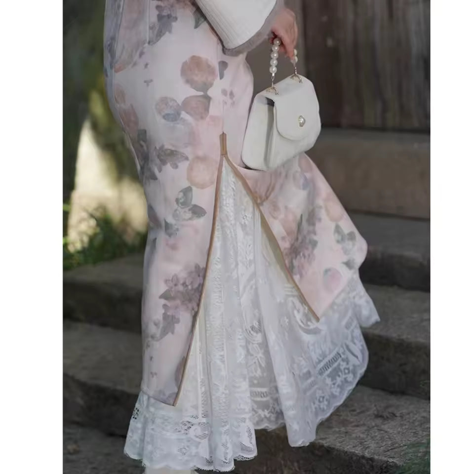 Person wearing a floral dress with a white lace overlay, holding a white handbag.