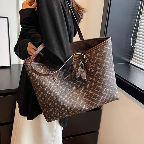 Person holding a brown patterned handbag indoors